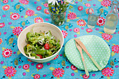 Schüssel mit Salat, daneben DIY-Schüsseldeckel aus Waschstuch und Besteck
