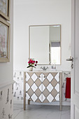 Waschtischmöbel mit Rautenmuster und Wandspiegel im Badezimmer