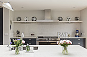 View past vases of flowers on island counter to kitchen counter