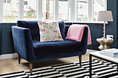 Comfortable blue armchair below window