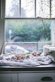 Fresh farm eggs of various colours on kitchen counter next to window