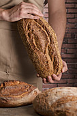 Bäcker hält frisch gebackenes Brot