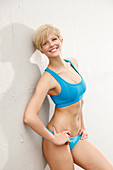 Blonde Frau in blauem Bustier und Bikinihose