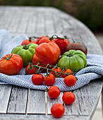 Verschiedene Tomaten auf Holztisch im Garten