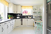 L-shaped kitchen counter in bright kitchen-dining room with white wooden floor