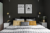 Doppelbett und Nachtkästchen im Schlafzimmer mit anthrazitfarbener Wand
