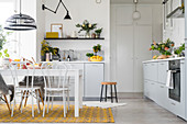 White kitchen with storage cupboards and dining area