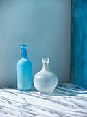 Blaue und weiße Glasflasche auf Marmoruntergrund