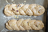 Unbaked yeast buns with raisins and almond flakes