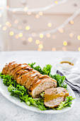 A turkey roll with nut stuffing on lettuce leaves for Christmas