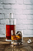 Whisky in Glas und Flasche auf Holztisch
