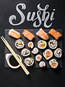 Sushi served on blackboard with the word Sushi handwritten with chalk