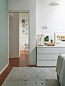 White sideboard next to open doorway in bedroom