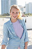 Junge blonde Frau in lila T-Shirt und Jeanshemd