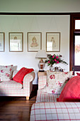 Red and floral cushions on checked sofas in living room
