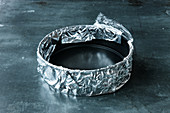 A springform tin being covered with tin foil