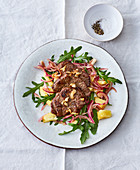 Marinated beef steaks on a pineapple and rocket salad