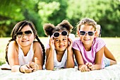 Girls lying on blanket in park