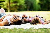 Girls lying on blanket in park