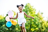 Girl running with balloons