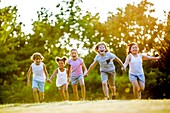 Children holding hands and running