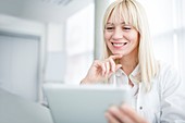 Doctor using tablet and smiling