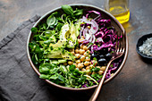 A salad bowl with avocado, chick peas, red cabbage and water cress
