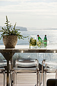 Classic chairs around metal table on balcony with sea view