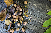 Walnuts whole and shelled on a wooden background (top view)