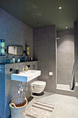 Runde, schwarze Mosaikfliesen im modernen Bad mit offener Dusche