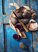 Purple potatoes wrapped in paper with a knife