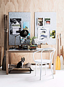 White chair and desk, mood board on wooden wall above