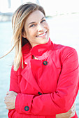 A blonde woman wearing a red trench coat