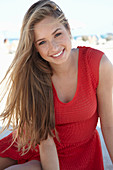 A young blonde woman wearing a red dress