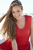 A young blonde woman wearing a red dress