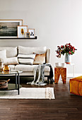 Upholstered sofa with cushions, wall shelf with pictures, side tables and coffee table