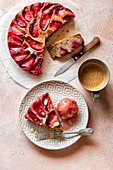Upside-down plum cake on a plate served with a dollop of ice cream
