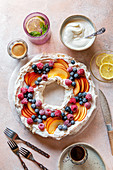 Pavlova wreath topped with fresh fruit on the table