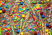 Assortment of bright, rainbow colored candies filling frame