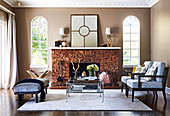Upholstered chairs, coffee table and upholstered bench in front of a fireplace