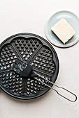 A waffle iron being greased