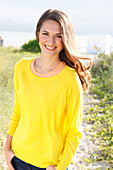 A brunette woman wearing a yellow jumper