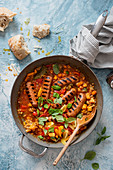 One pot chorizo style sausages with pearl barley, sweet potatoes, tomatoes and basil