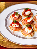 Blinis with creme fraiche smoked salmon and salmon caviar with red pepper and dill garnish