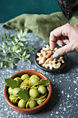 A bowl of green olives wth mixed nuts