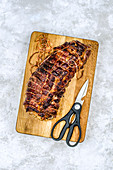 Meat loaf on a wooden Board with ? scissors to remove the rope