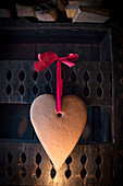 Festive gingerbread heart hung from red ribbon