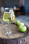 A glass of cider and green apples