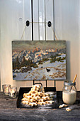 Pile of cinnamon stars under old painting of winter landscape