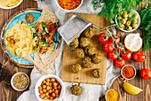 Fried falafel balls on wooden board surrounded with different ingredients